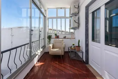 a balcony with a chair and a window at T3 Apartamento do Tenis in Albufeira