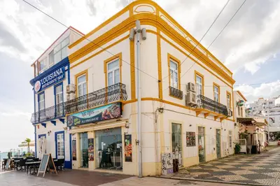 a yellow and white building on the side of a street at Down Town Beach House in Albufeira