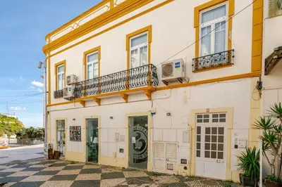 a building with two balconies on a street at Down Town Beach House in Albufeira