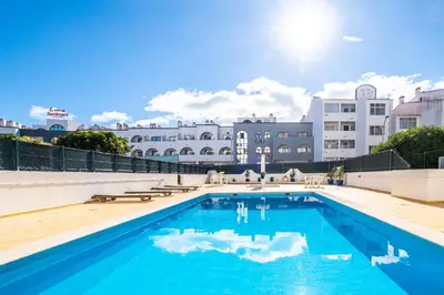 a large swimming pool in front of a building at Beautifull CentralApart W/pool in Albufeira