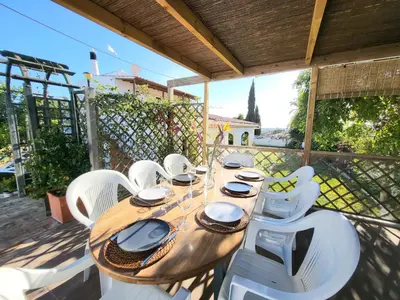 a wooden table and white chairs on a patio at Villa Estrelícia - Pool - Free wi-fi - New in Booking in Loulé