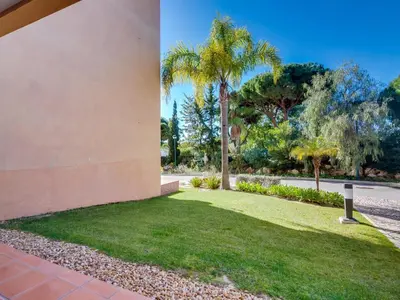 a side view of a yard with palm trees at AL - Apartamento Vila Sol F5 AO in Vilamoura