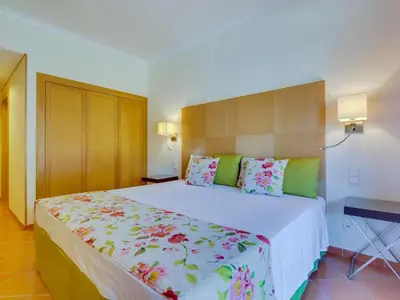 a bedroom with a large white bed with flowers on it at AL - Apartamento Vila Sol F5 AO in Vilamoura
