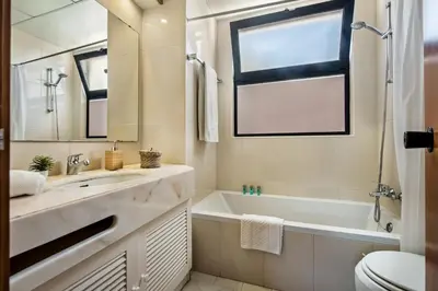a bathroom with a sink and a tub and a toilet at Victory Village Beach Villa - Quinta do Lago in Quinta do Lago