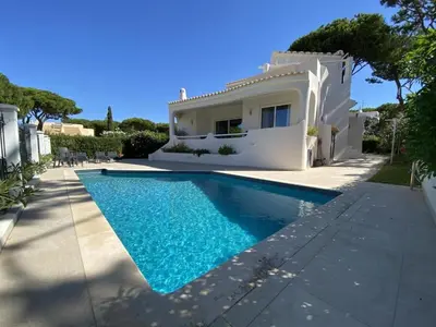 a villa with a swimming pool in front of a house at Lovely Vilamoura Villa 4 Bedrooms Villa Pinhal Short Drive To Marina in Quarteira