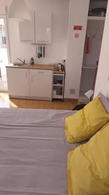 a white bed in a room with a kitchen at 