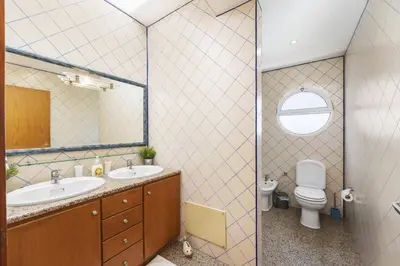 a bathroom with a sink and a toilet and a mirror at Villa Casa Morim by Villa Plus in Olhos de Água