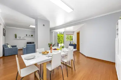 a dining room and living room with a white table and chairs at Villa Casa Morim by Villa Plus in Olhos de Água