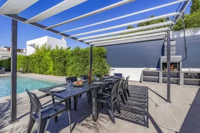 a patio with a table and chairs and a pool at Villa Casa Morim by Villa Plus in Olhos de Água