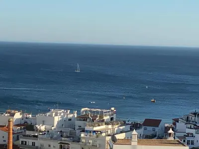 a group of white buildings by the ocean with a boat at Sunset Haven in Albufeira - Short walk to Oldtown in Albufeira