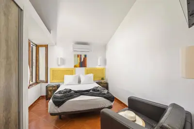 a bedroom with a bed and a couch at Villa Damasco by Villa Plus in Albufeira