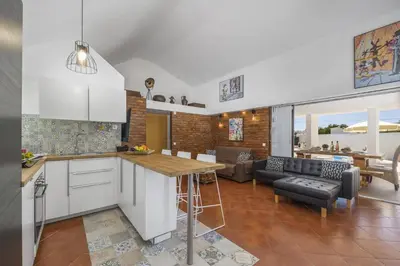 a kitchen and living room with a table and a couch at Villa Damasco by Villa Plus in Albufeira