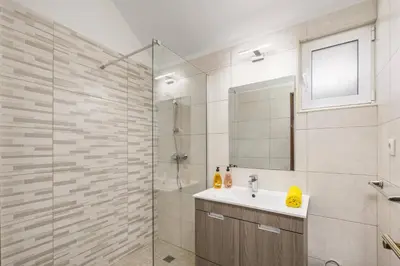a bathroom with a shower and a sink and a mirror at Villa Damasco by Villa Plus in Albufeira