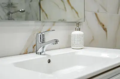 a bathroom sink with a soap dispenser on it at Apartamento Algarve, located center of Vilamoura in Quarteira