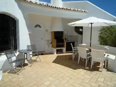 a patio with a table and chairs and an umbrella at Casa Francisco : Family Villa with private pool. Near to beach in Albufeira