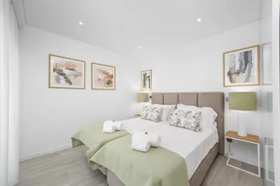 a white bedroom with two beds with towels at Terraços de Quarteira Green by Real Properties in Quarteira