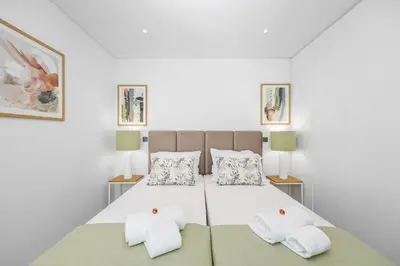 a bedroom with a bed with two white towels at Terraços de Quarteira Green by Real Properties in Quarteira