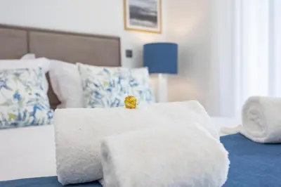 a white bed with a gold ring on top of it at Terraços de Quarteira Green by Real Properties in Quarteira