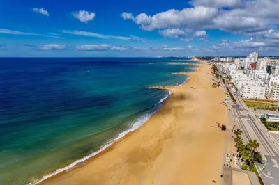 an aerial view of a beach with buildings and the ocean at Terraços de Quarteira Green by Real Properties in Quarteira