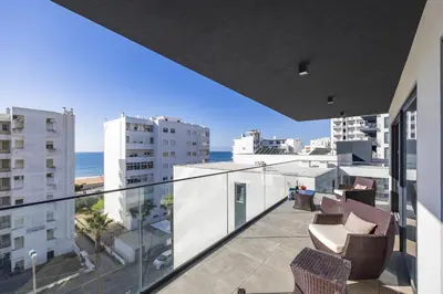a balcony with chairs and a view of the ocean at Terraços de Quarteira Green by Real Properties in Quarteira