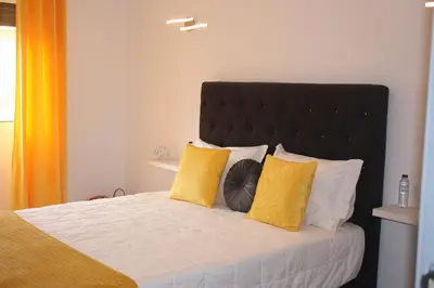 a bedroom with a bed with yellow and white pillows at Yucca in Faro