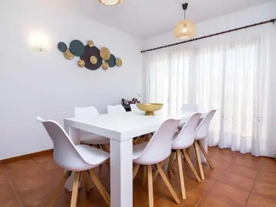 a white dining room with a white table and chairs at Villa Dogueno by Stay ici Algarve Holiday Rental in Albufeira