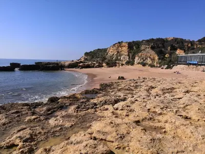 a sandy beach with rocks and the ocean at Central Albufeira 2-B Apt Sleeps 6 Pool Parking in Areias Sao Joao