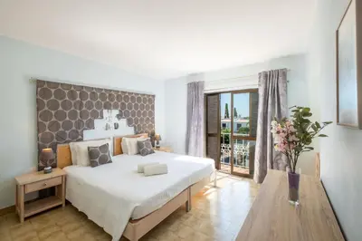 a bedroom with a large bed and a large window at Apartment Luna - Resort with a pool area with a lounge bar in Albufeira