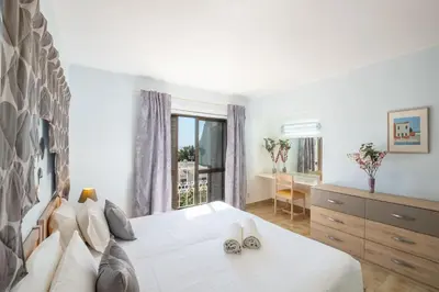 a bedroom with a bed with two shoes on it at Apartment Luna - Resort with a pool area with a lounge bar in Albufeira
