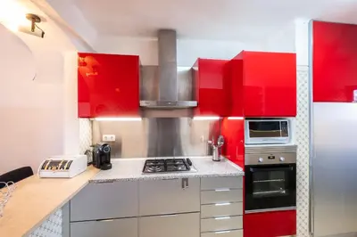 a kitchen with red cabinets and a stove at Apartment Luna - Resort with a pool area with a lounge bar in Albufeira