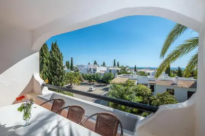 a balcony with chairs and a view of a city at Apartment Luna - Resort with a pool area with a lounge bar in Albufeira