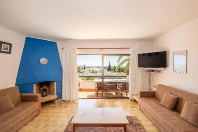 a living room with a couch and a fireplace at Apartment Luna - Resort with a pool area with a lounge bar in Albufeira