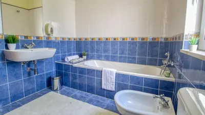 a blue tiled bathroom with a tub and a sink at 8-Bed Villa in Vilamoura-Sleeps-Playground-Pool in Vilamoura