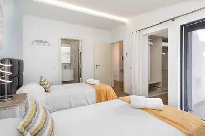 a white room with two beds and a mirror at Centralgarve - Villa Crown 22 in Quarteira
