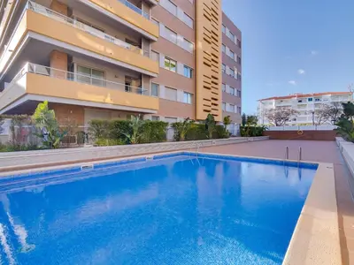 a swimming pool in front of a building at AL - Apartamento Carteia in Quarteira