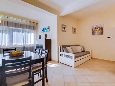 a living room with a table and a couch at AL - Apartamento Pinhal da Praia in Vilamoura