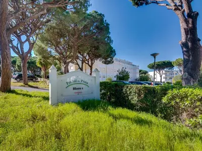 a sign in the grass in a park with trees at AL - Apartamento Pinhal da Praia in Vilamoura