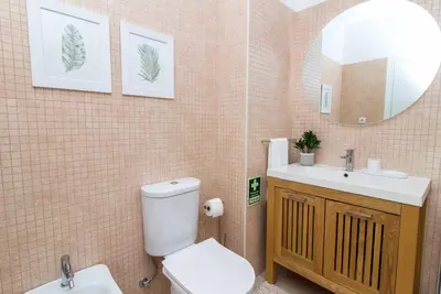 a bathroom with a toilet and a sink and a mirror at Oura 7 in Albufeira