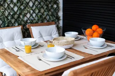 a wooden table with plates and bowls of orange juice at Oura 7 in Albufeira