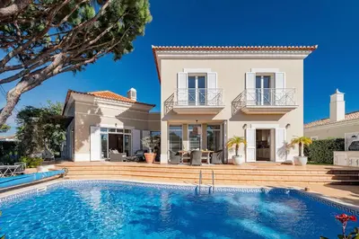 a villa with a swimming pool in front of a house at Villa Anna - Vale de Lobo in Faro