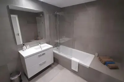 a bathroom with a sink and a tub and a mirror at Panoramic View Apartment in Albufeira