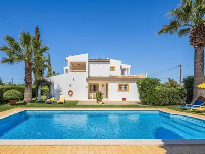 a villa with a swimming pool in front of a house at Vila Montejunto in Albufeira