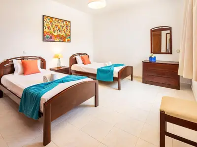 a bedroom with two beds and a mirror at Vila Montejunto in Albufeira