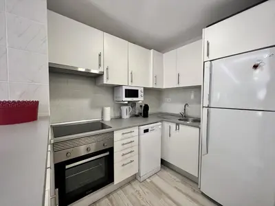 a kitchen with white cabinets and a refrigerator at Vilamoura Marina Mar 2 With Pool by Homing in Vilamoura