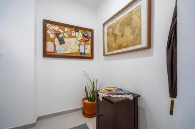 a white wall with two framed pictures and a table at Downtown Lady Terrace in Faro