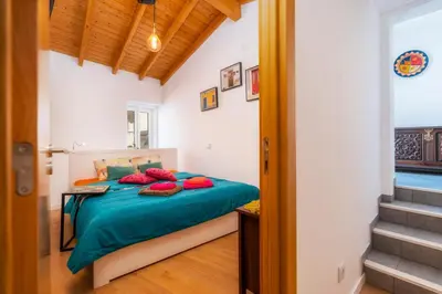 a bedroom with a bed with blue sheets and red pillows at Downtown Lady Terrace in Faro