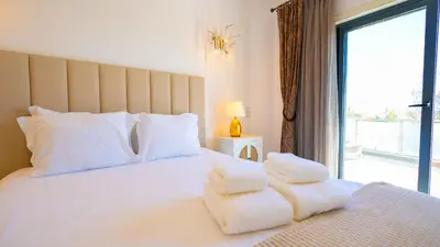 a bedroom with a white bed with towels on it at Ocean View Villa in Boliqueime