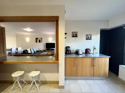 a kitchen with a counter and two stools in a room at Albufeira Modern 4 With Pool by Homing in Albufeira