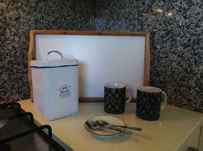 a table with two cups and a plate and utensils at Spacieux Appartement Logis des Fées de la Marina en rez-de-chaussée de chaussée in Albufeira