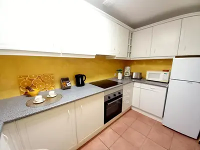 a kitchen with white cabinets and white appliances at Apartamento Joyce by Sunnyway in Albufeira